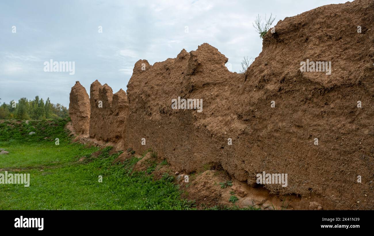 Close-up background of the wall of an old house made of clay mixed with straw. Old type of construction. Clay wall of straw and mud. Stock Photo