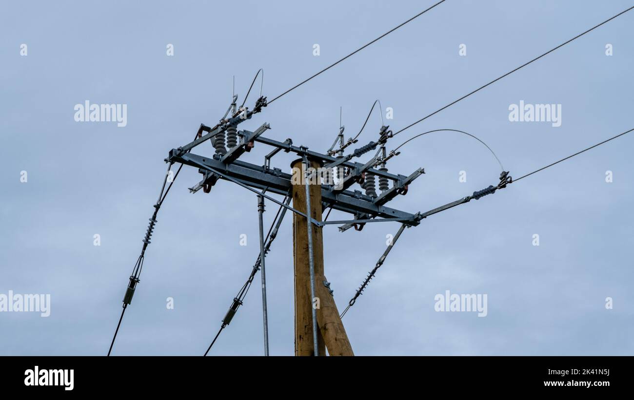 High-voltage disconnector on a wooden transmission line support. Stock Photo