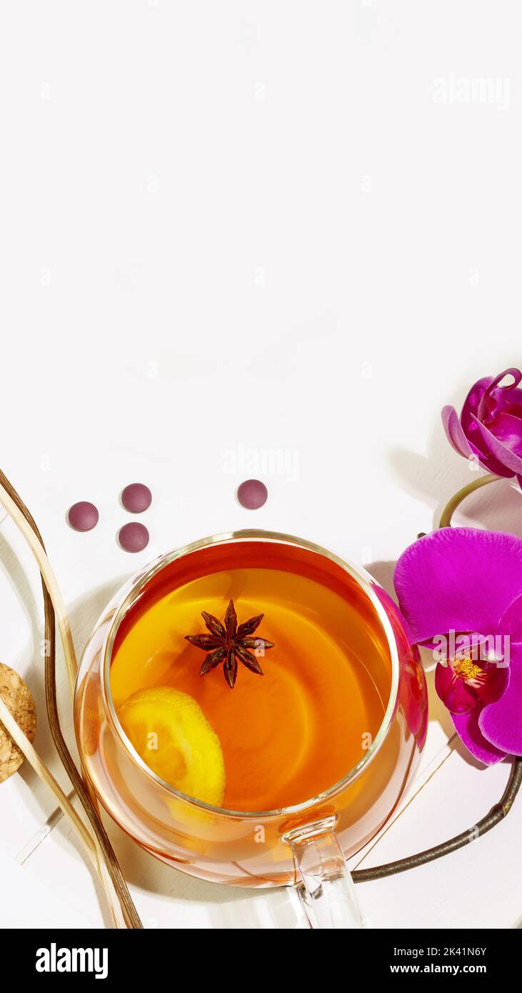 Home relaxing concept. Wooden tray with cup of fruit tea with lemon slice, aroma sticks and orchids on white background with copy space. Concept of Me Stock Photo