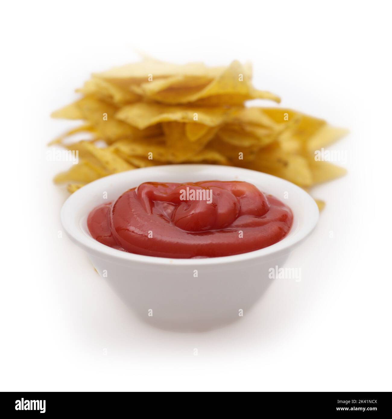 Tomato ketchup with chips behind Stock Photo Alamy