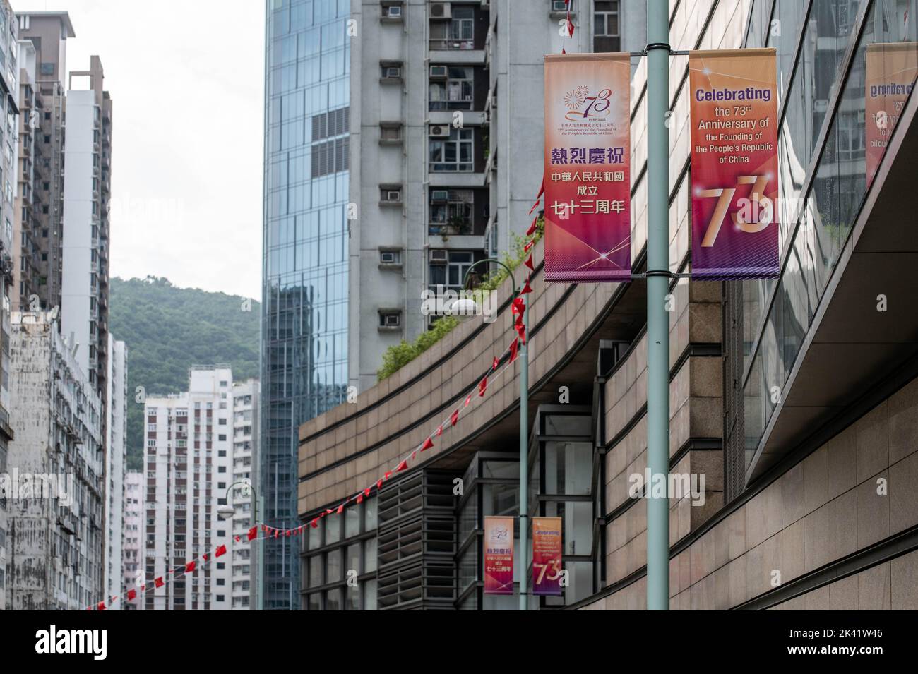 A newly-placed banner and flags hang on a quiet commercial street on Hong Kong Island. With no city-wide celebrations planned for China's National Day and police on high alert for protests, signs acknowledging the 73rd anniversary of the People's Republic of China are few and far between. Stock Photo