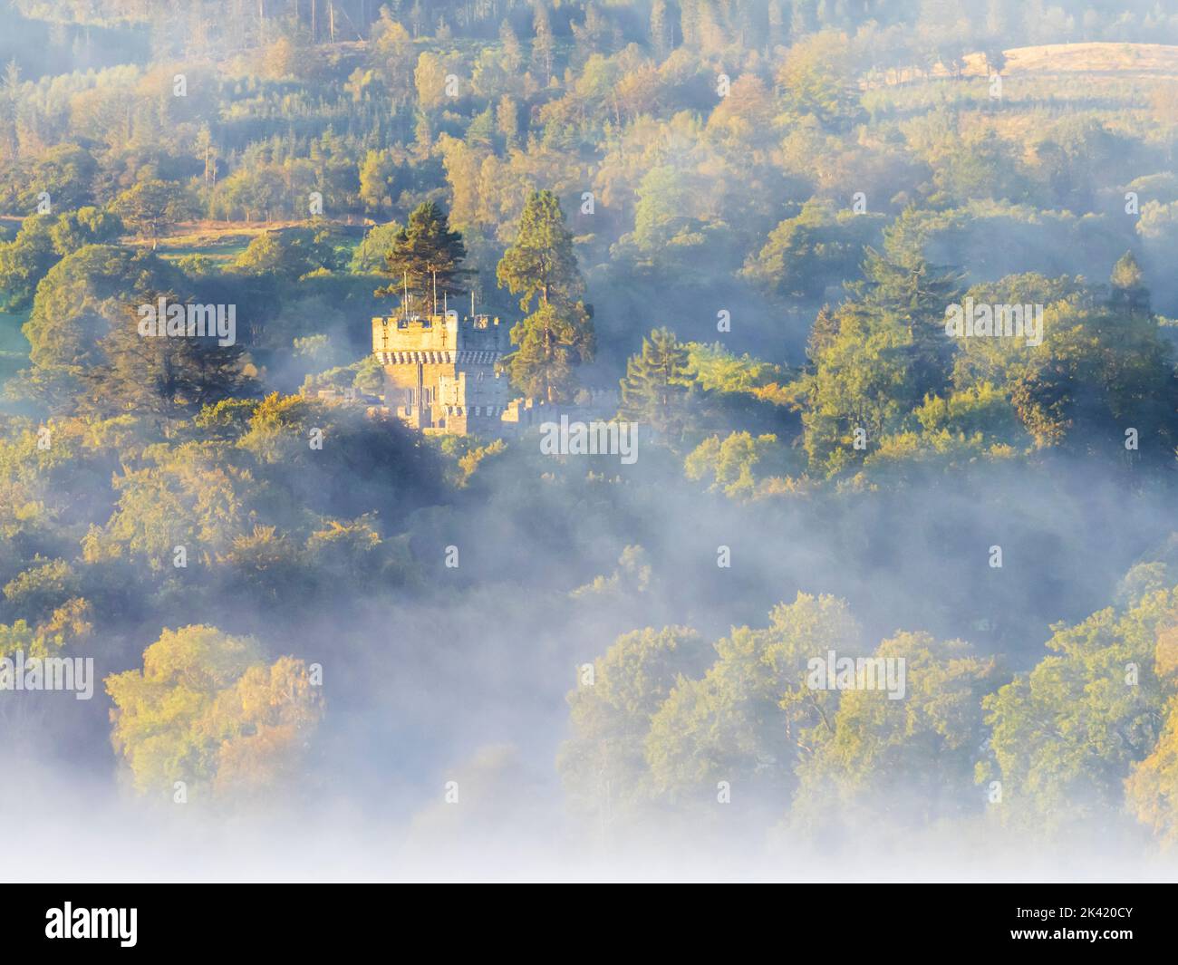 Autumn mist over Wray Castle, Lake District, UK at dawn. Stock Photo