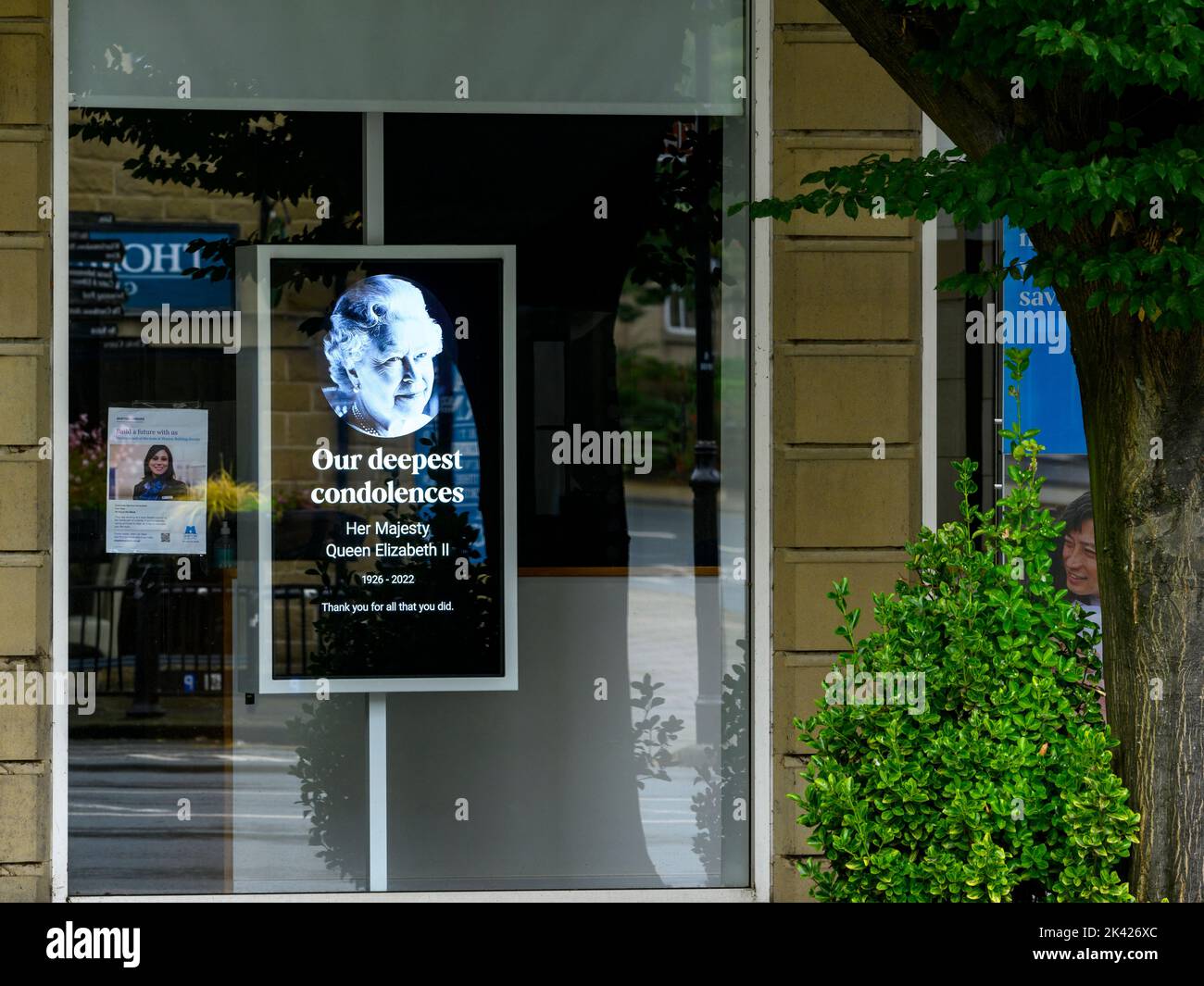 Tribute on Queen's death (poignant electronic digital shop front image, Elizabeth 2 II face, remembering commemorating, paying respects) - England UK. Stock Photo