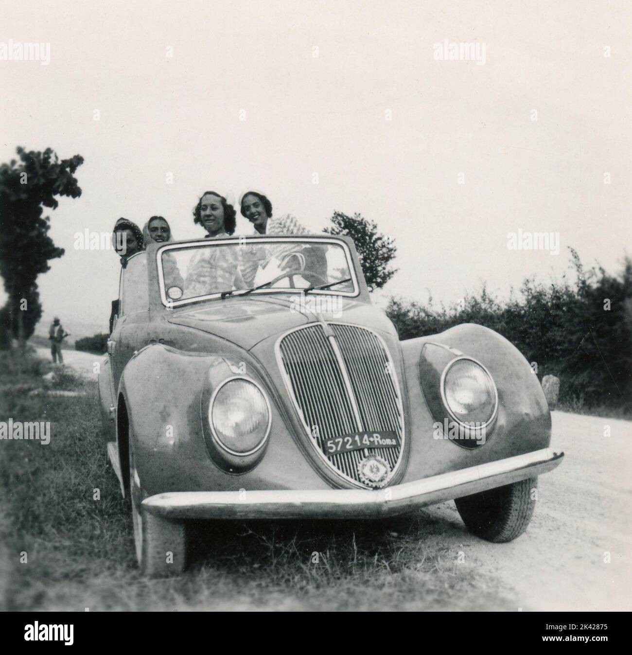 Four women on an old FIAT 1500 Cabriolet car, 1940s Stock Photo