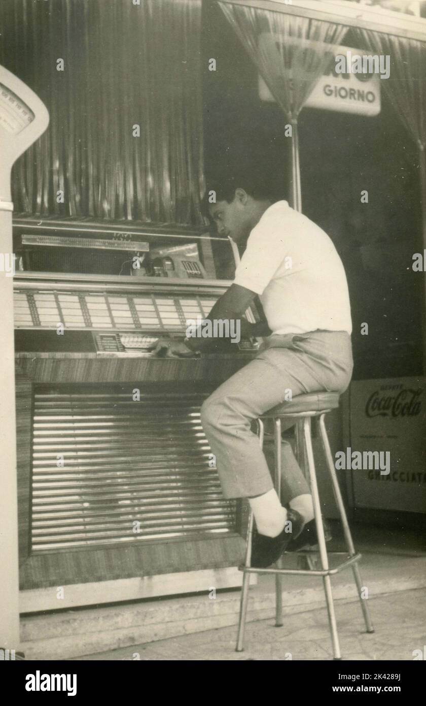 Boy listening to the music from the jukebox, Italy 1950s Stock Photo