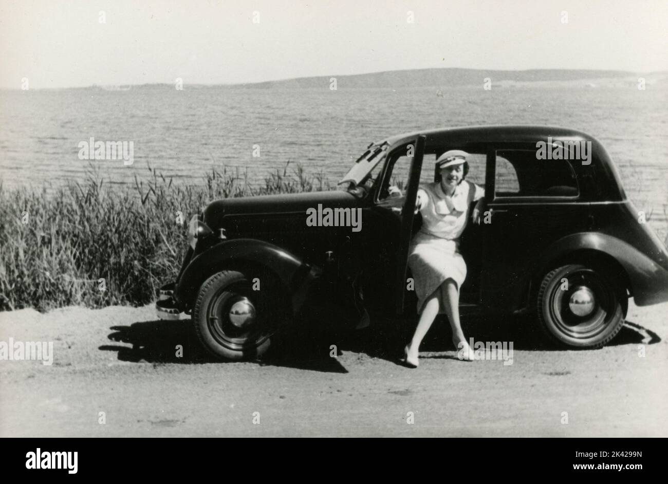 A woman close to the beach with a FIAT 1100 Balilla car, Italy 1940s Stock Photo