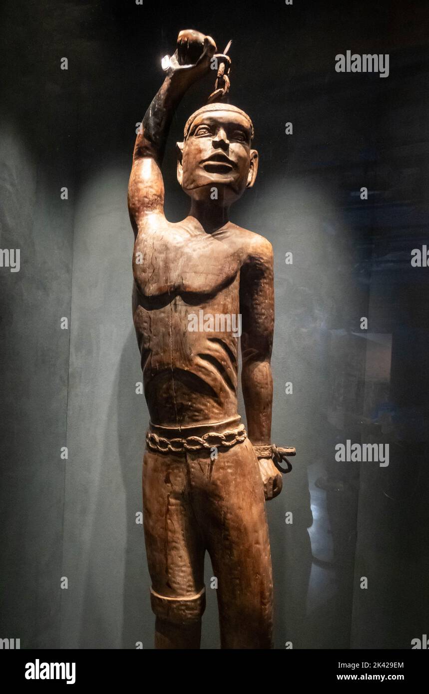 Carved wood statue of. black man breaking his chains at International Slavery Museum, Royal Albert Dock, Liverpool Stock Photo