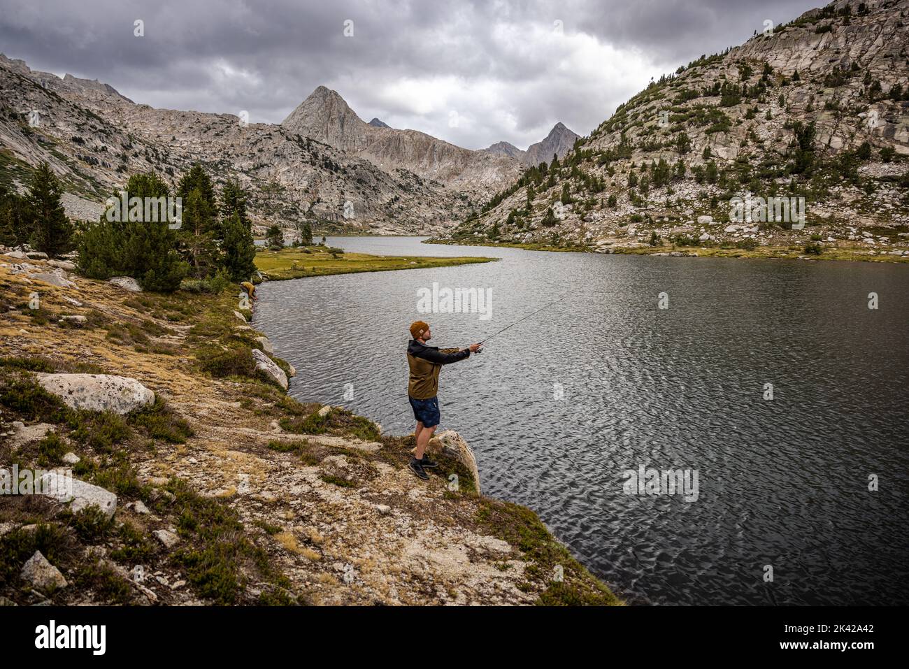 Casting out a line at an alpine lake. Stock Photo