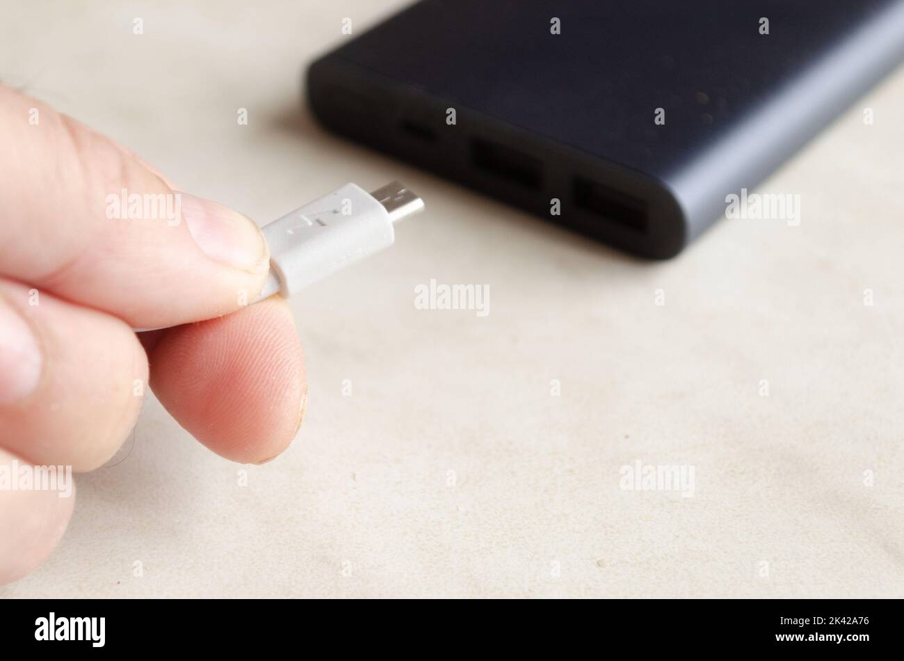 a man holds a charging cable for charging a powerbank Stock Photo