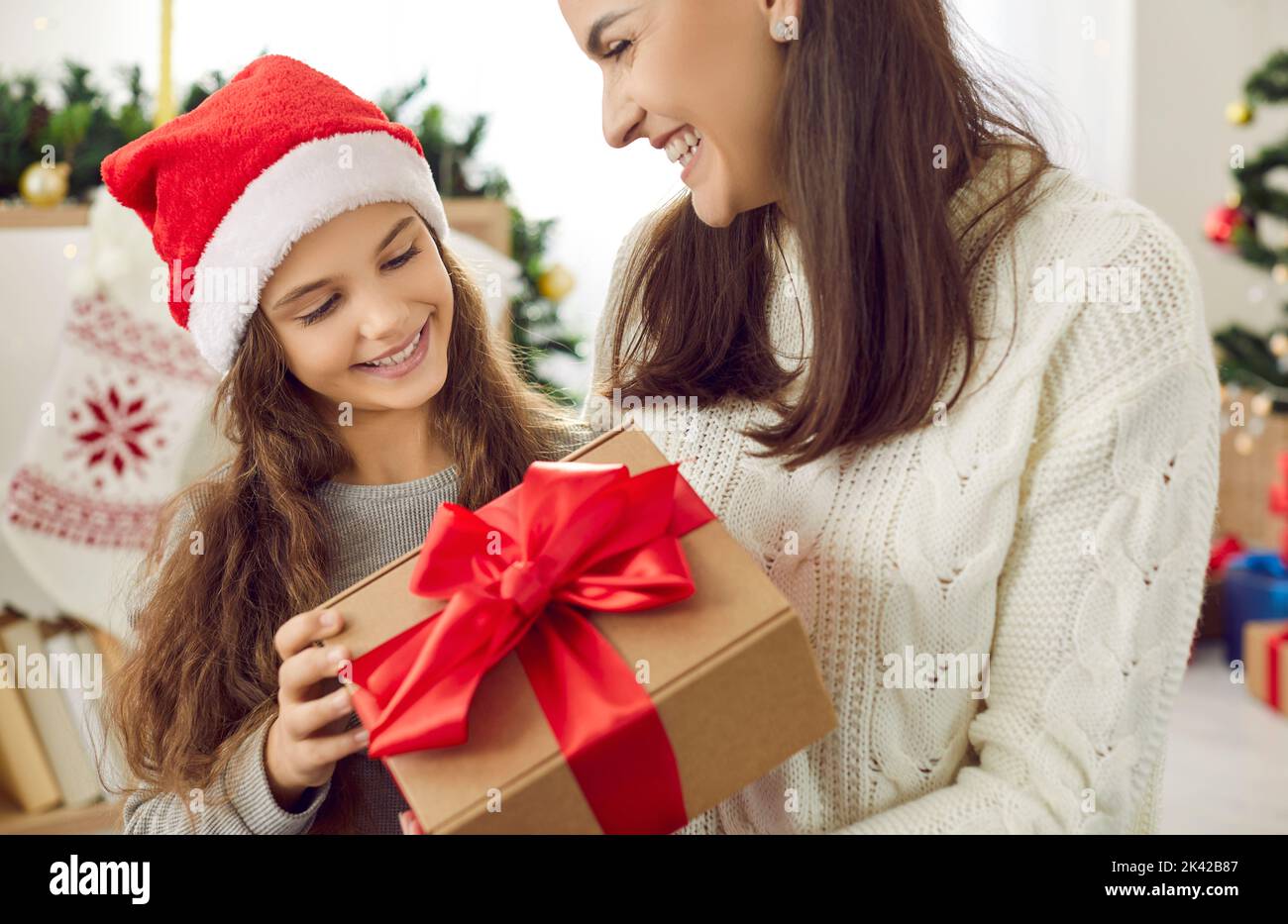Caring mother congratulate smiling daughter with Christmas Stock Photo