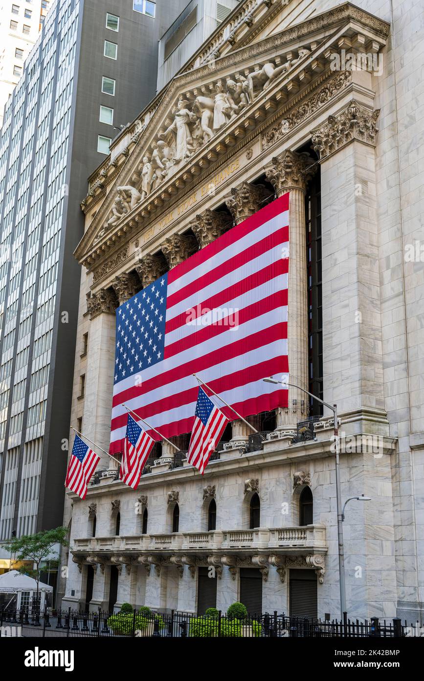 The facade of New York Stock Exchange (NYSE) building adorned with the US flags, Wall Street, Lower Manhattan, New York, USA Stock Photo