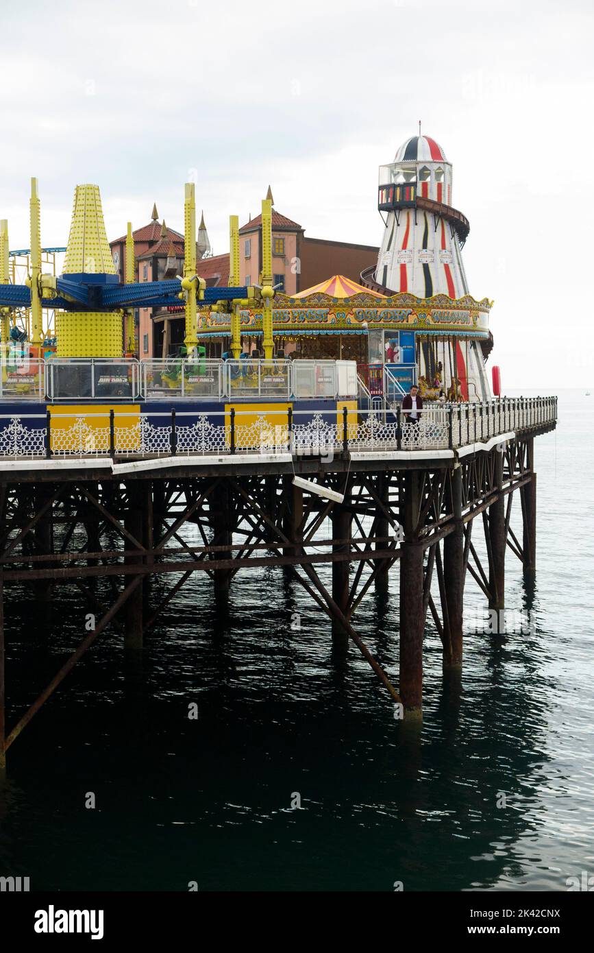 Fair / fairground with amusements, attractions, and rides, at the end of Brighton Palace Pier. UK. Pier is supported by cast iron screw piles. (131) Stock Photo