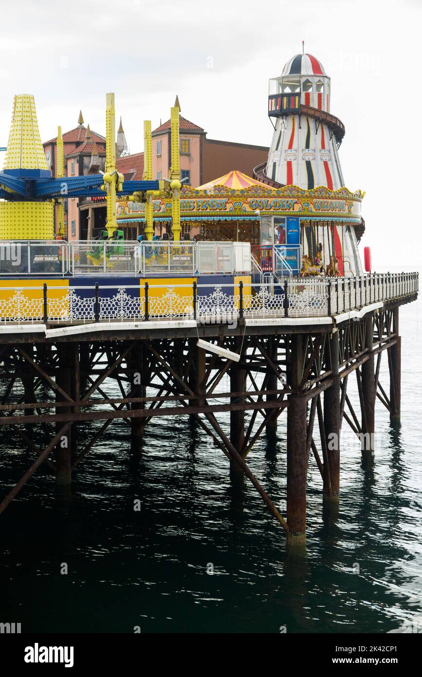 Fair / fairground with amusements, attractions, and rides, at the end of Brighton Palace Pier. UK. Pier is supported by cast iron screw piles. (131) Stock Photo