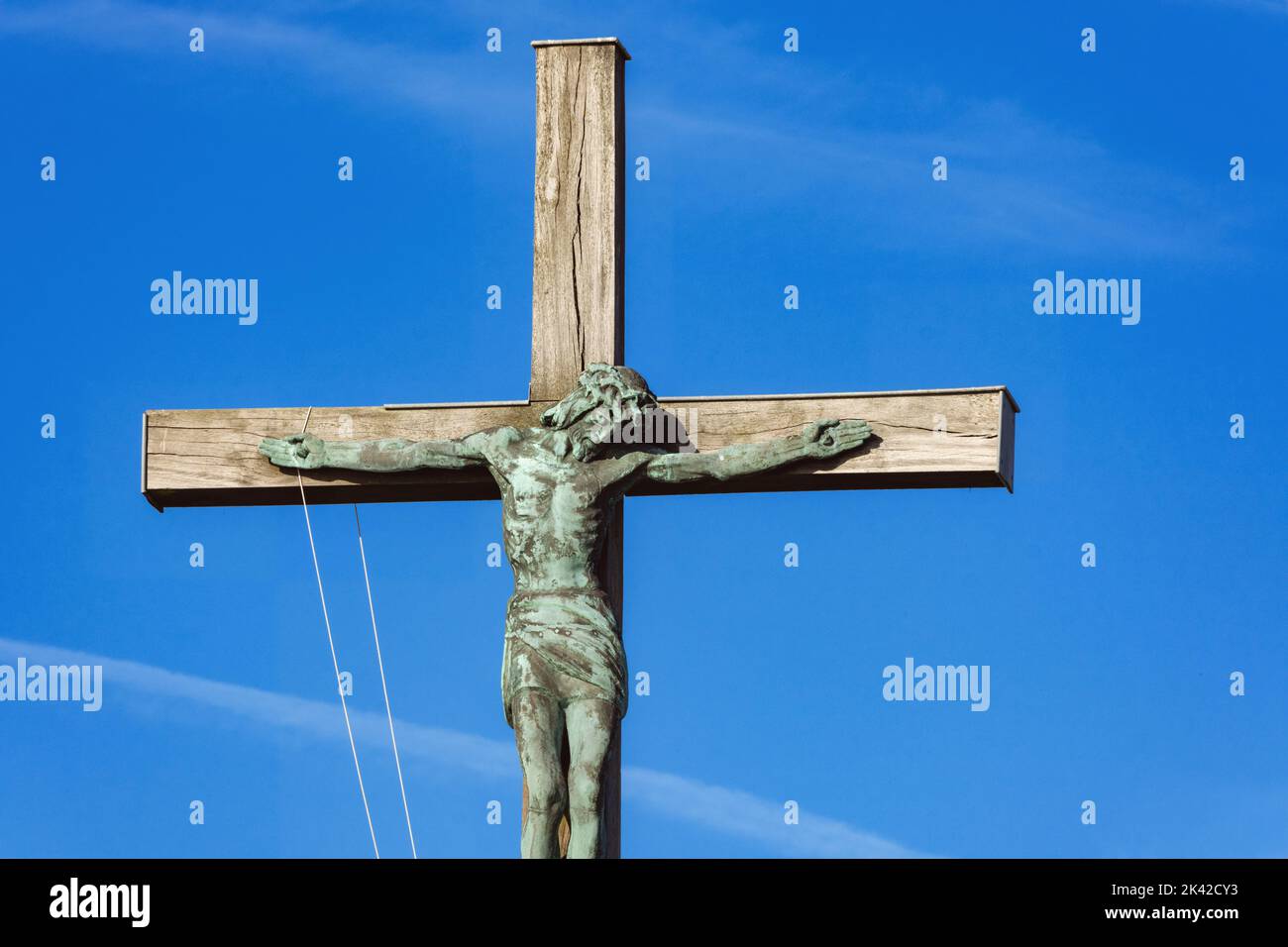 Statue of Christ on the cross against a blue sky in France Stock Photo