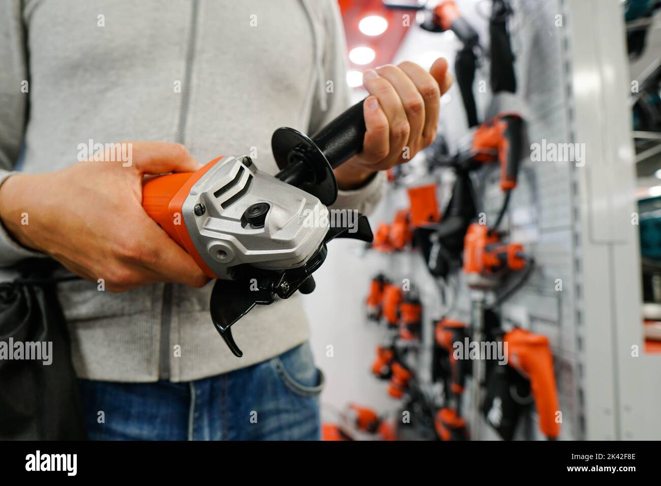 Cloe up of man is looking on new angle grinder at store. Stock Photo