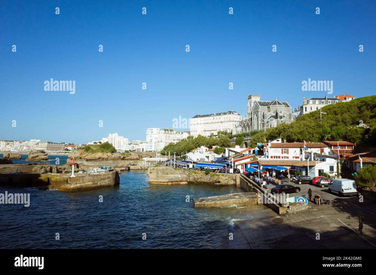 Biarritz, French Basque Country, France - July 19th, 2019 : Cityscape with Saint Eugene Church and fishing port in foreground. Stock Photo