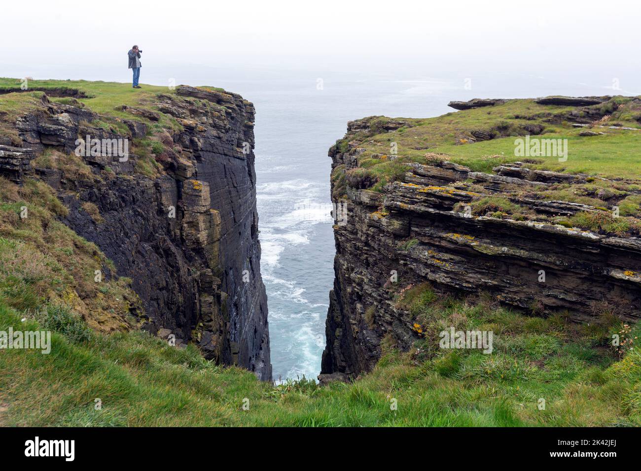 Tourist taking pictures to Cliffs in Brough of Birsay, The Mainland of Orkney, Scotland, UK Stock Photo