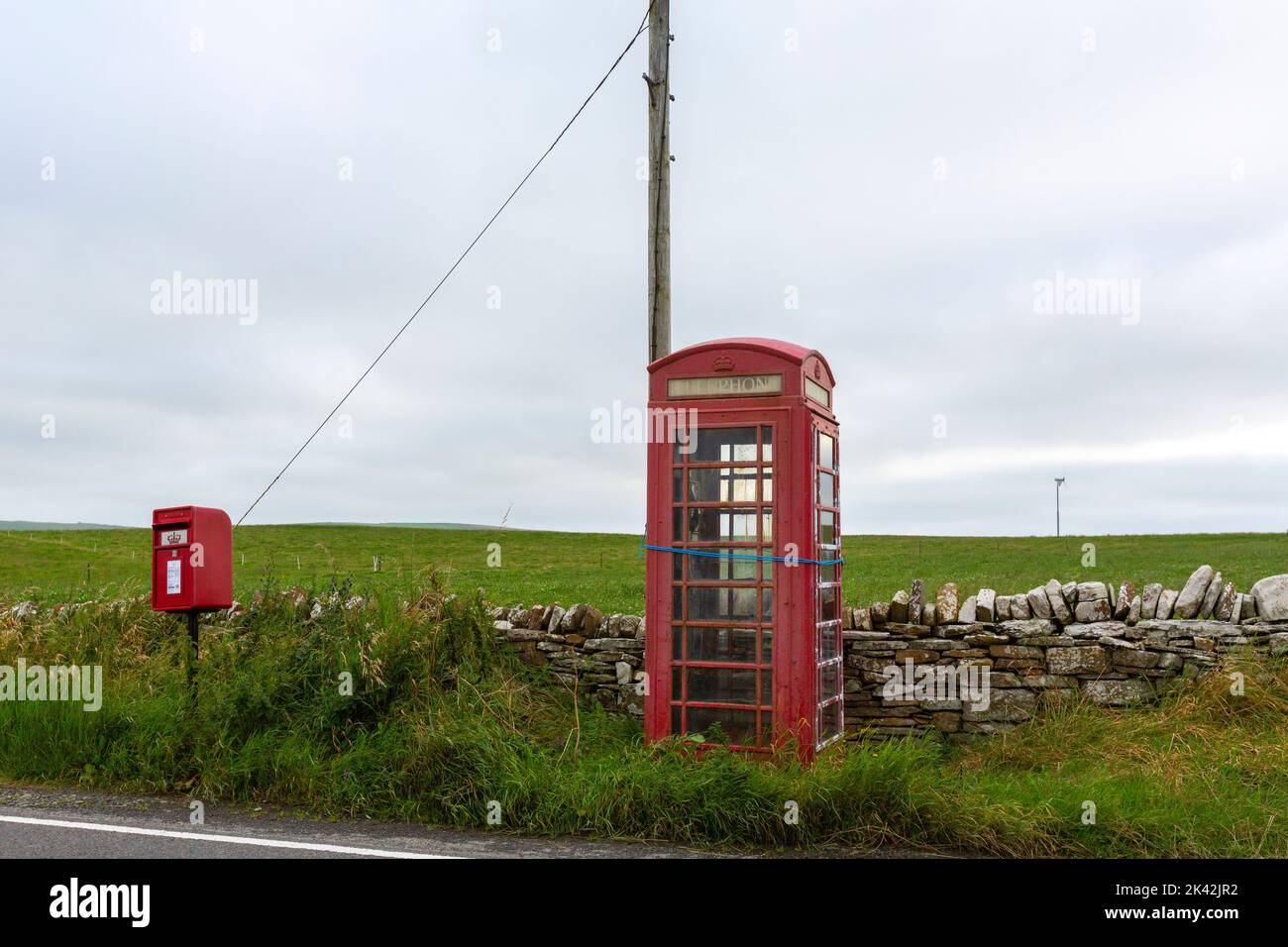 Red mailbox and telephone in Brough of Birsay, The Mainland of Orkney, Scotland, UK Stock Photo