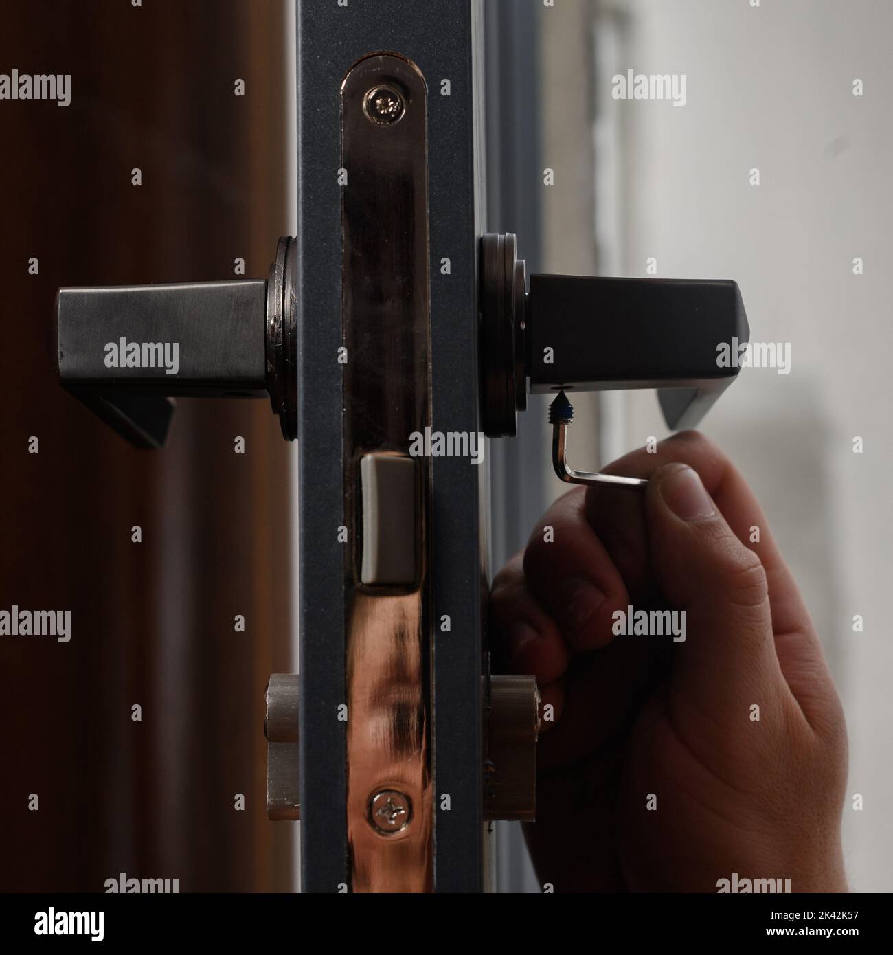 The craftsman installs the door handle with the help of a sprocket key