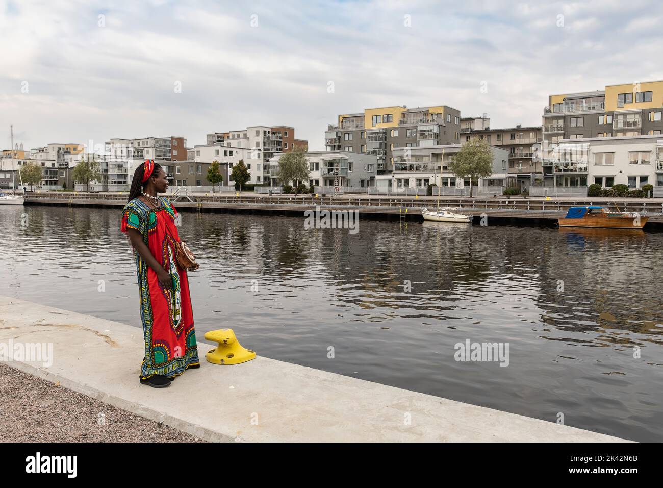 African woman looks across the river and wonders how housing prices ...
