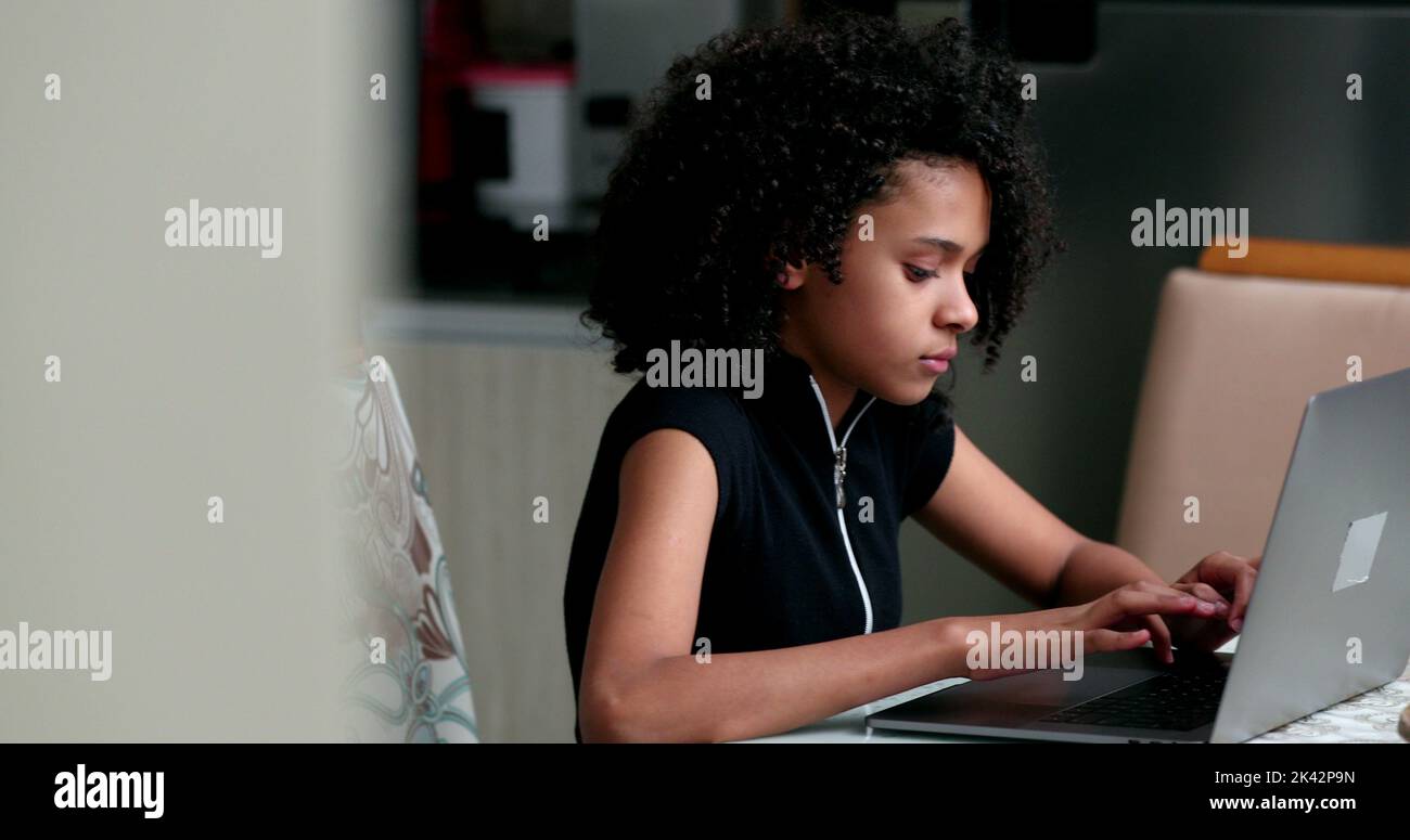 Candid black teen girl using laptop computer studying Stock Photo - Alamy
