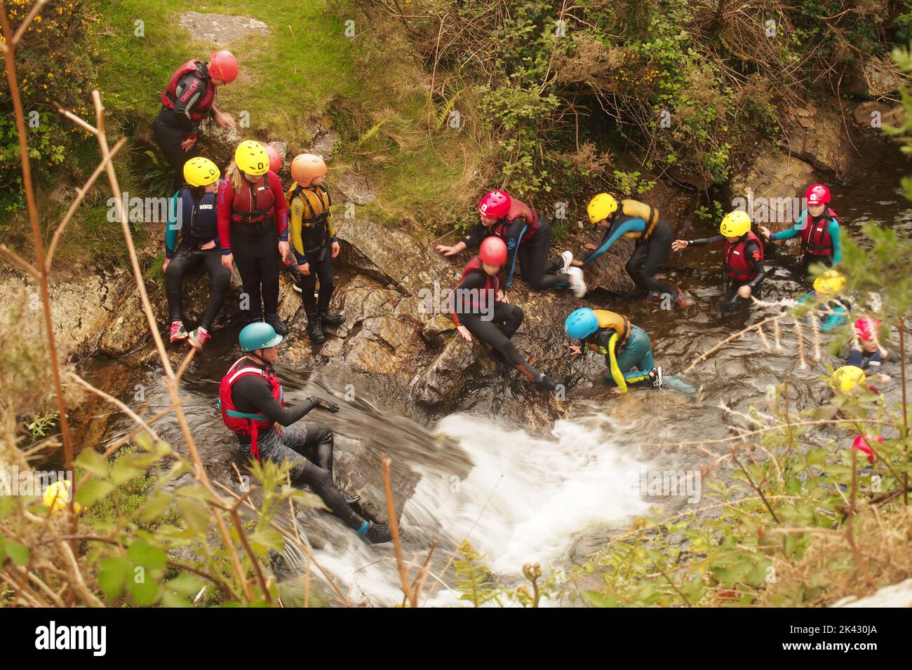 Looking down on a group of adventure school age children in wetsuits