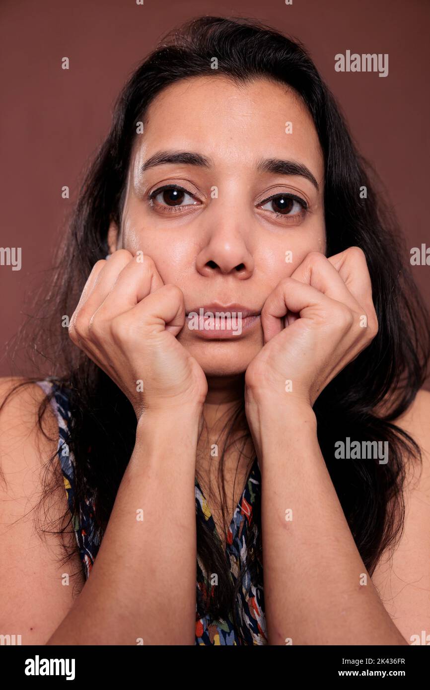 Indian woman holding clenched fists on cheeks closeup portrait, cute