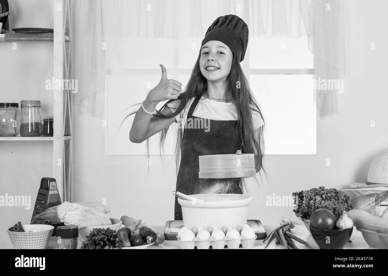 culinary and cuisine. happy childhood. happy child wear cook uniform. chef girl in hat and apron. kid cooking food in kitchen. choosing a career Stock Photo