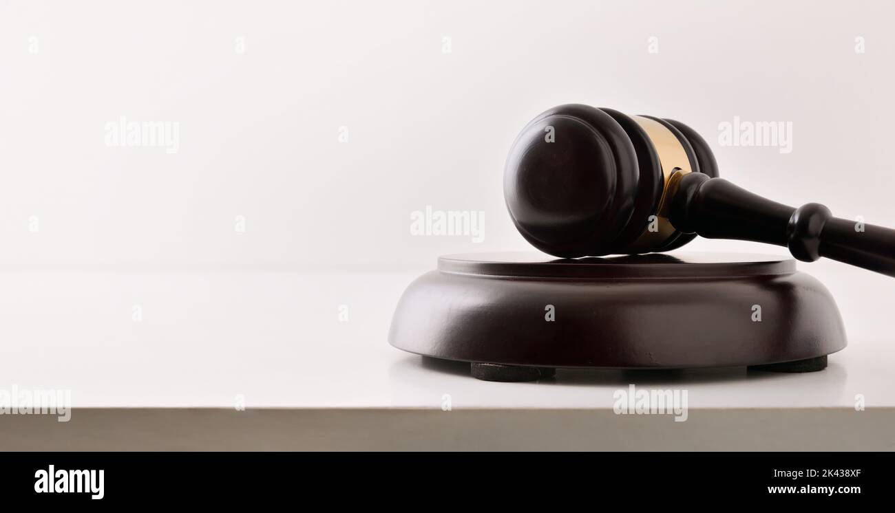 Detail of background of judge's gavel on white table and white isolated background. Front view Stock Photo