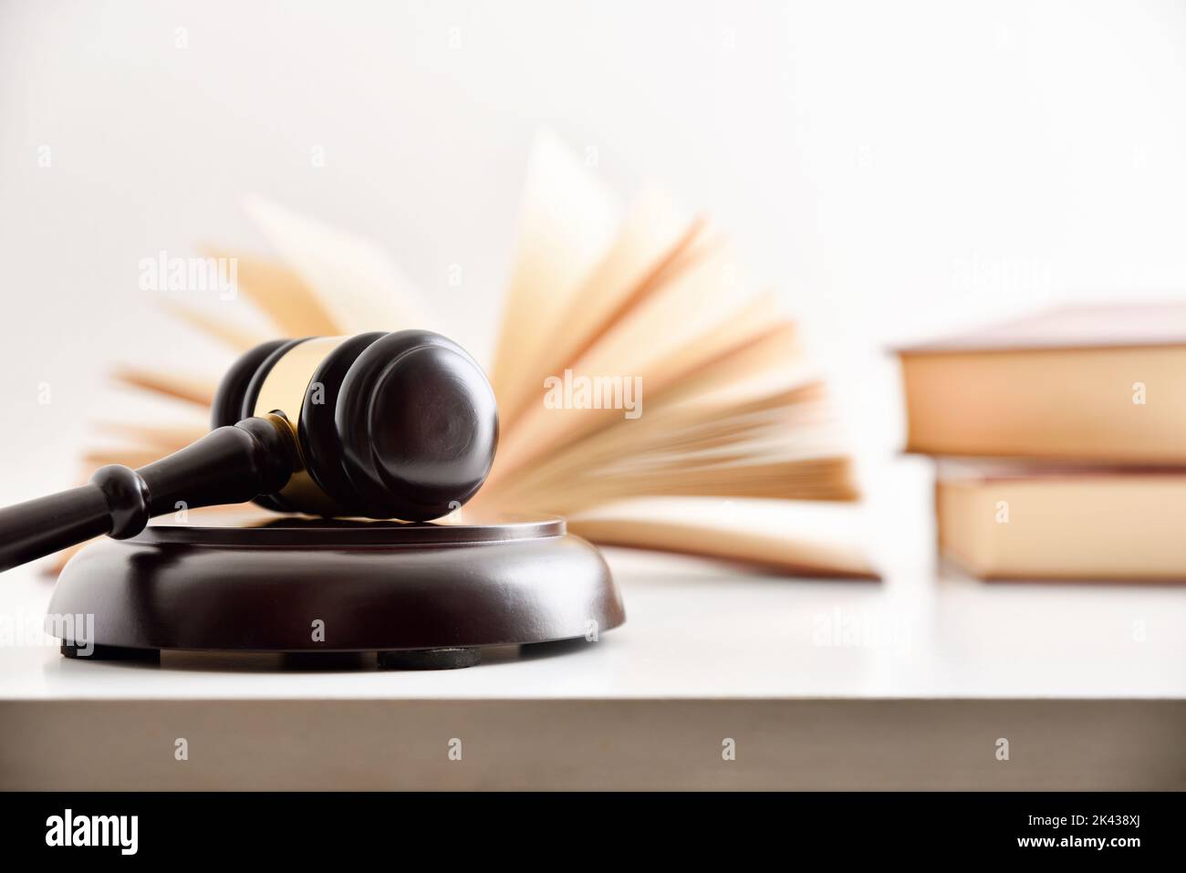 Judge's mallet and books on the table with white background. Law and advocacy concept. Front view Stock Photo