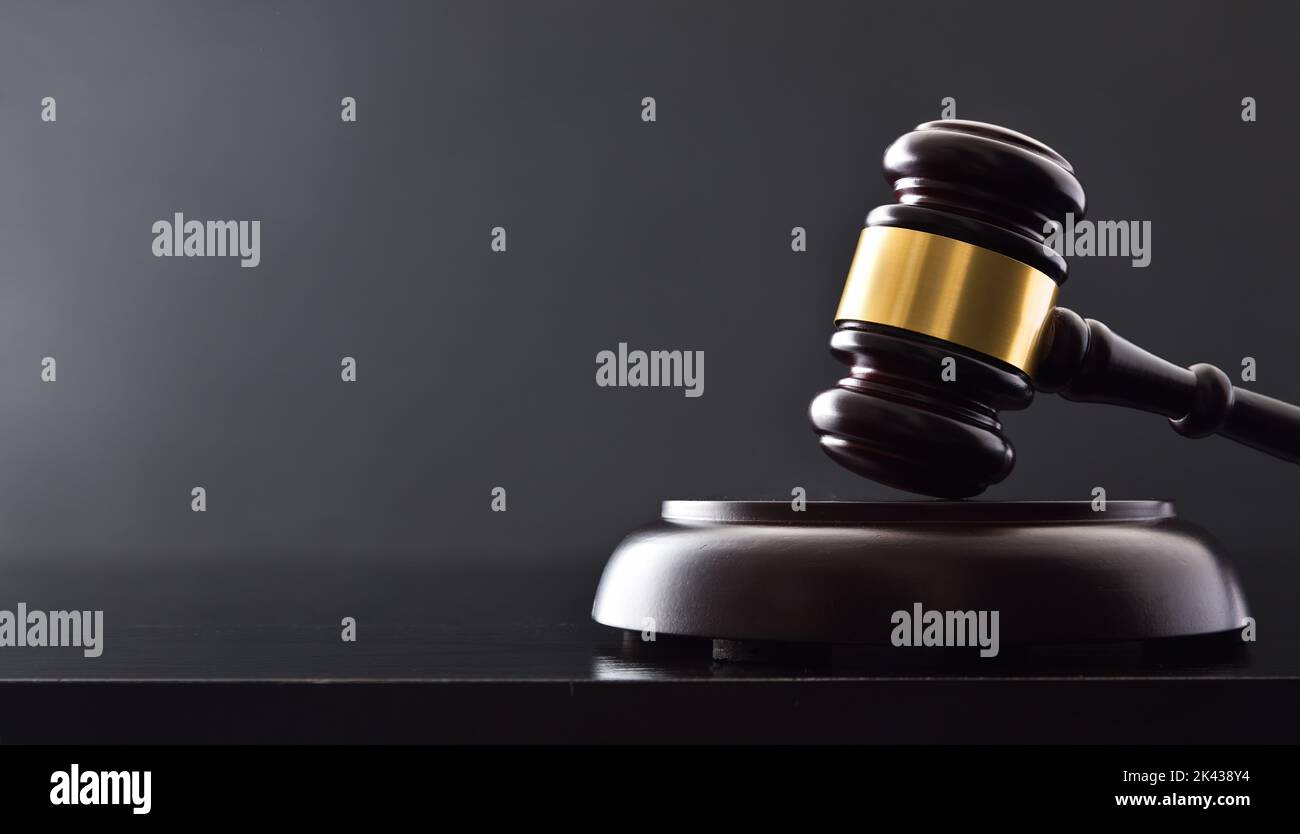 Detail of background of judge's gavel on white table and black isolated background. Front view Stock Photo