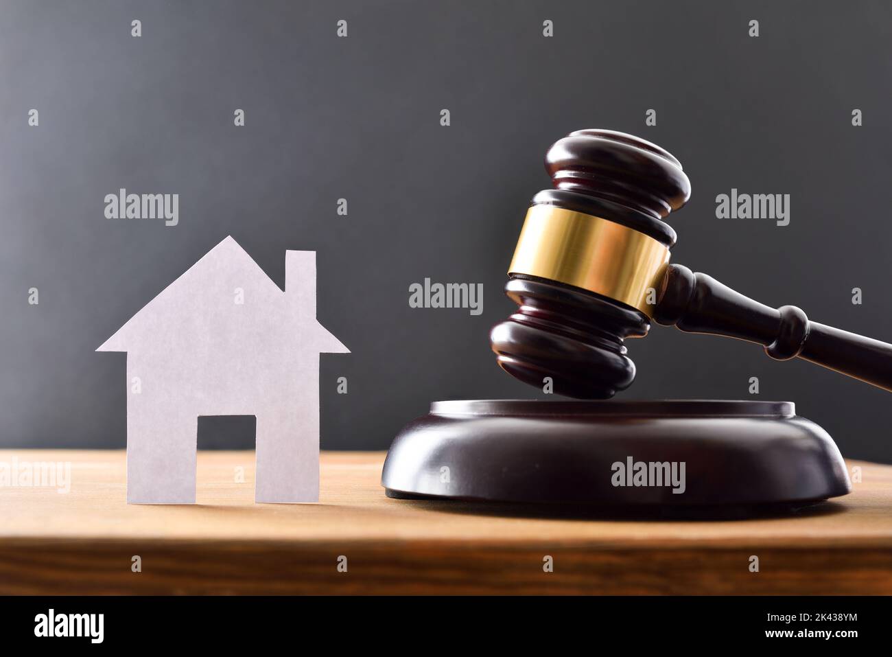 Housing reference judgment concept with house cutout and gavel on wooden table and black