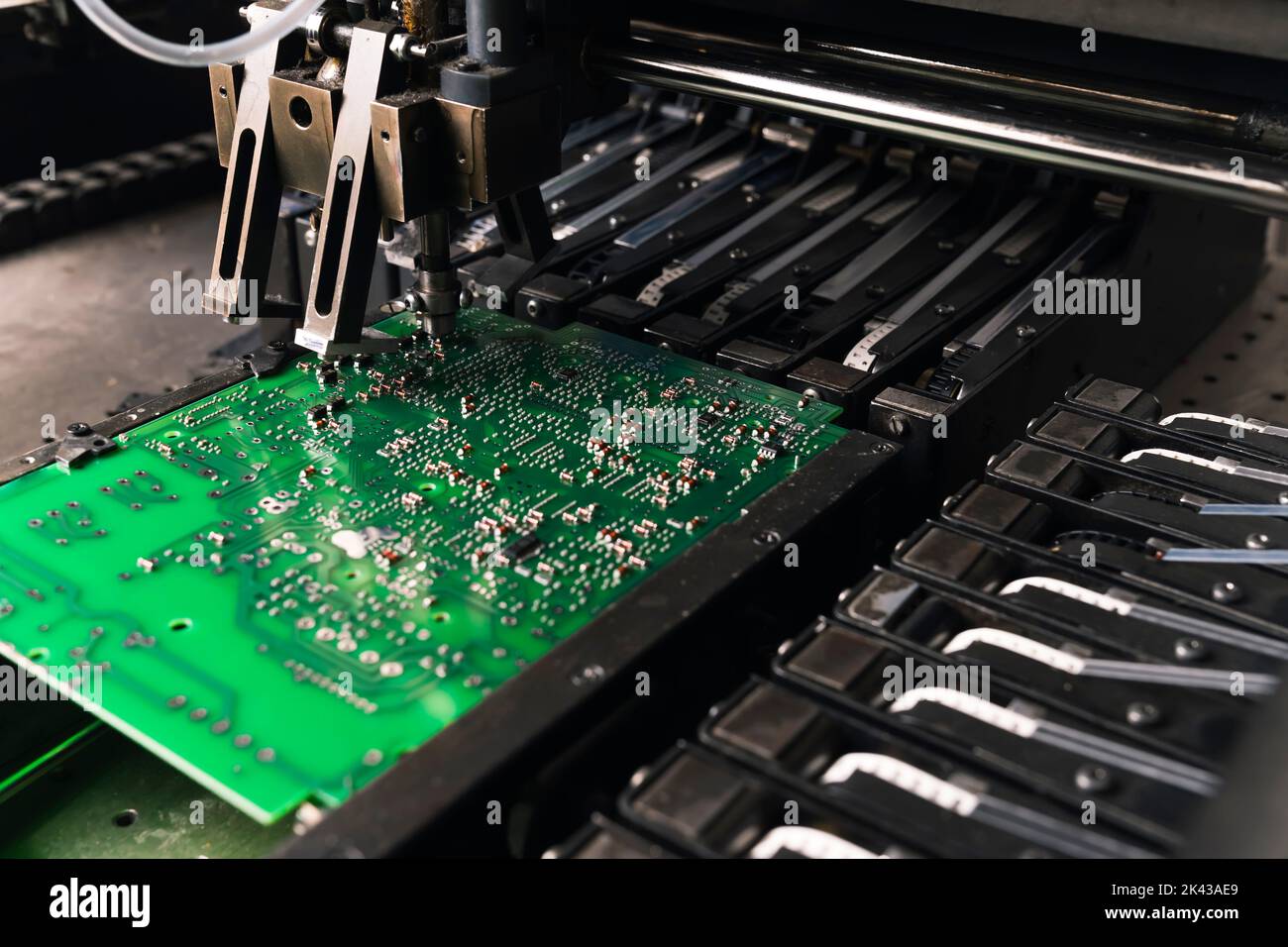 Close-up shot of SMD surface-mount device working on printed circuit board PCB. Assembling electrical components. Precision technology. Horizontal Stock Photo