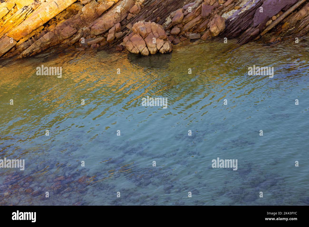 Landscape of sea shore with rocks and calm water with reflection Stock Photo