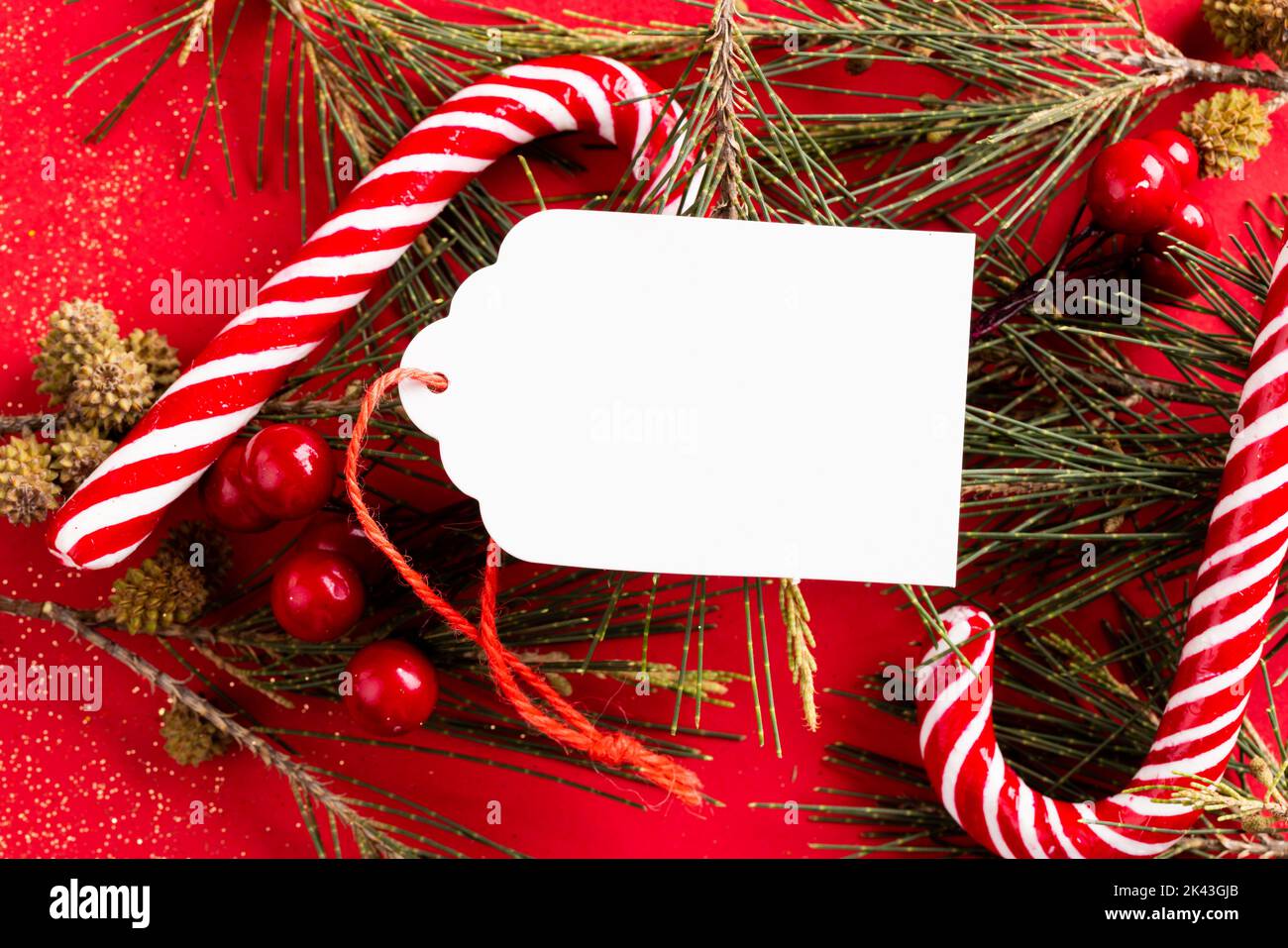 Image of christmas decoration with gif tag and copy space on red background Stock Photo