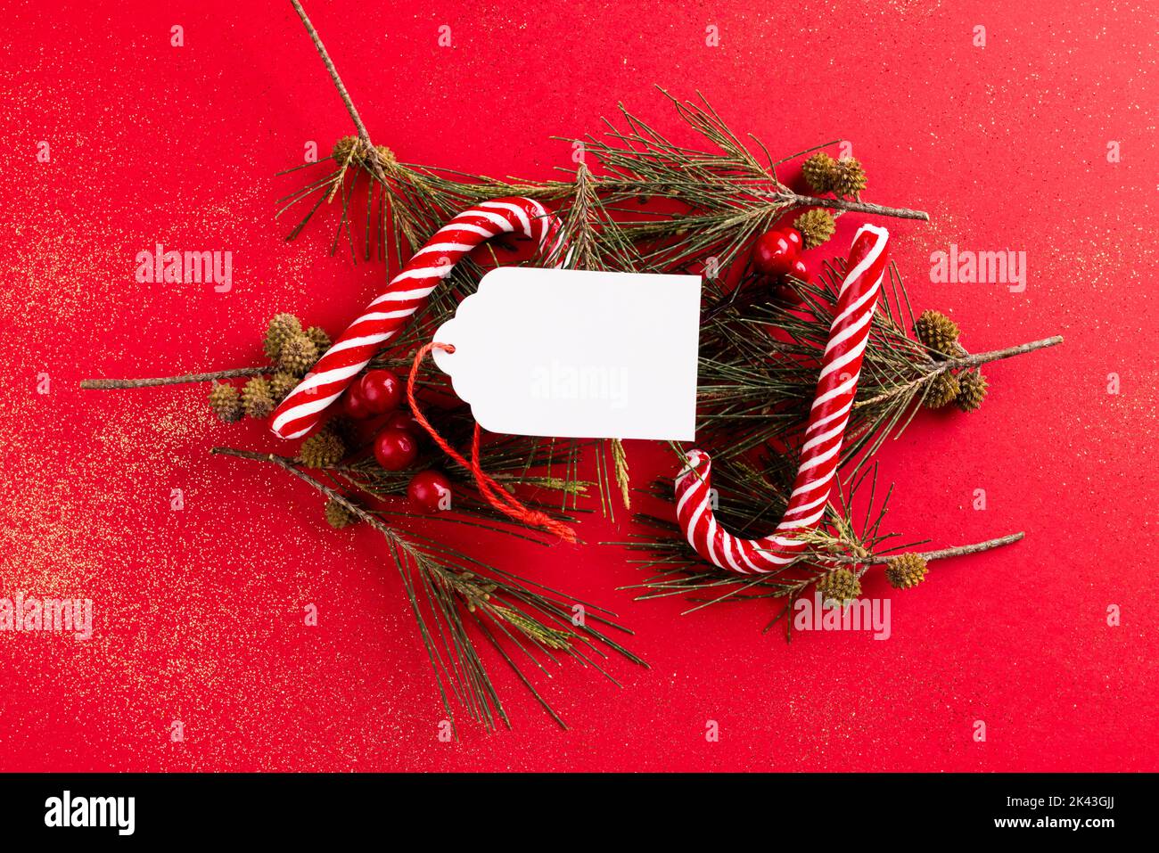 Image of christmas decoration with gif tag and copy space on red background Stock Photo