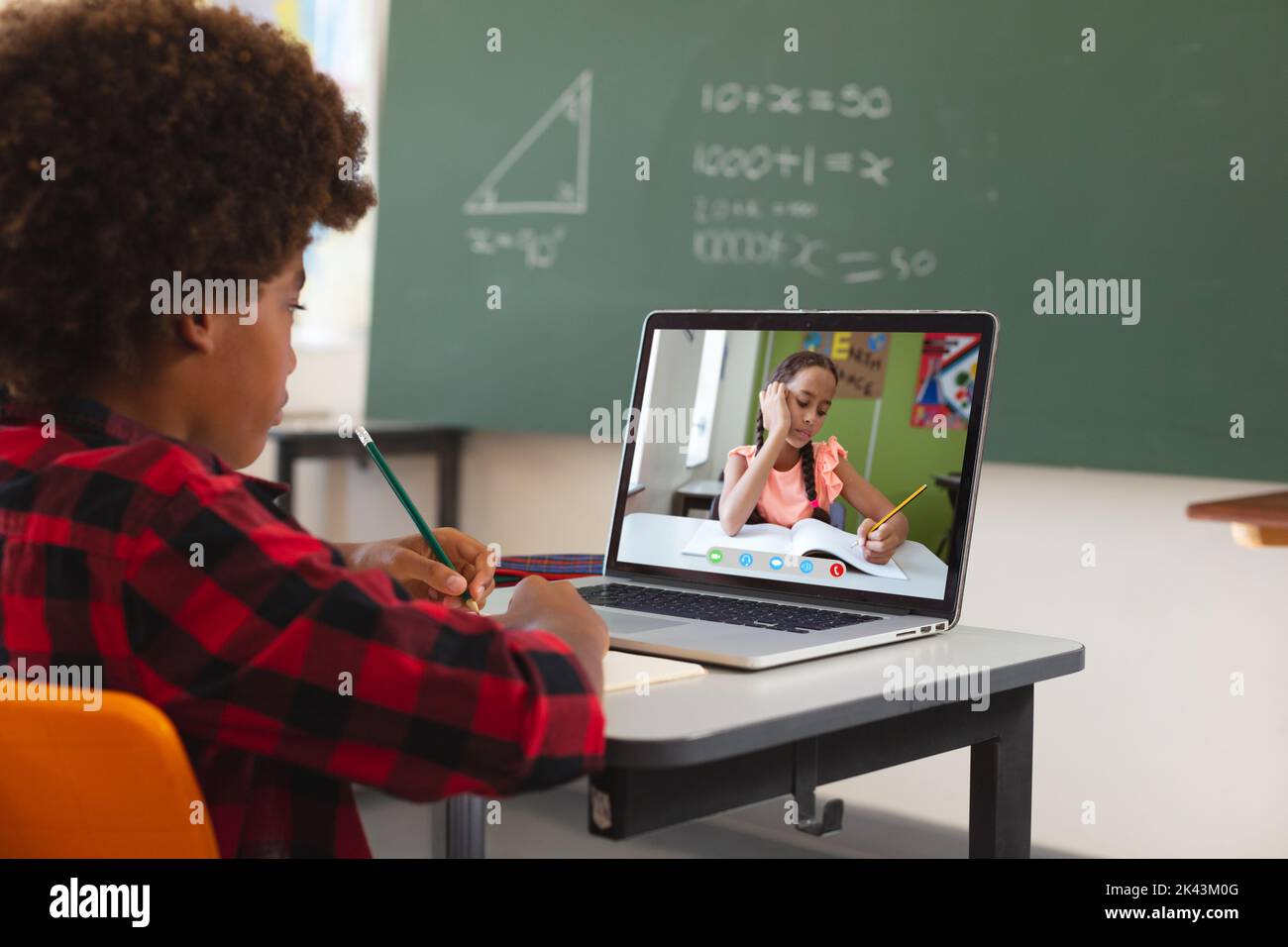 African american boy using laptop for video call, with biracial ...