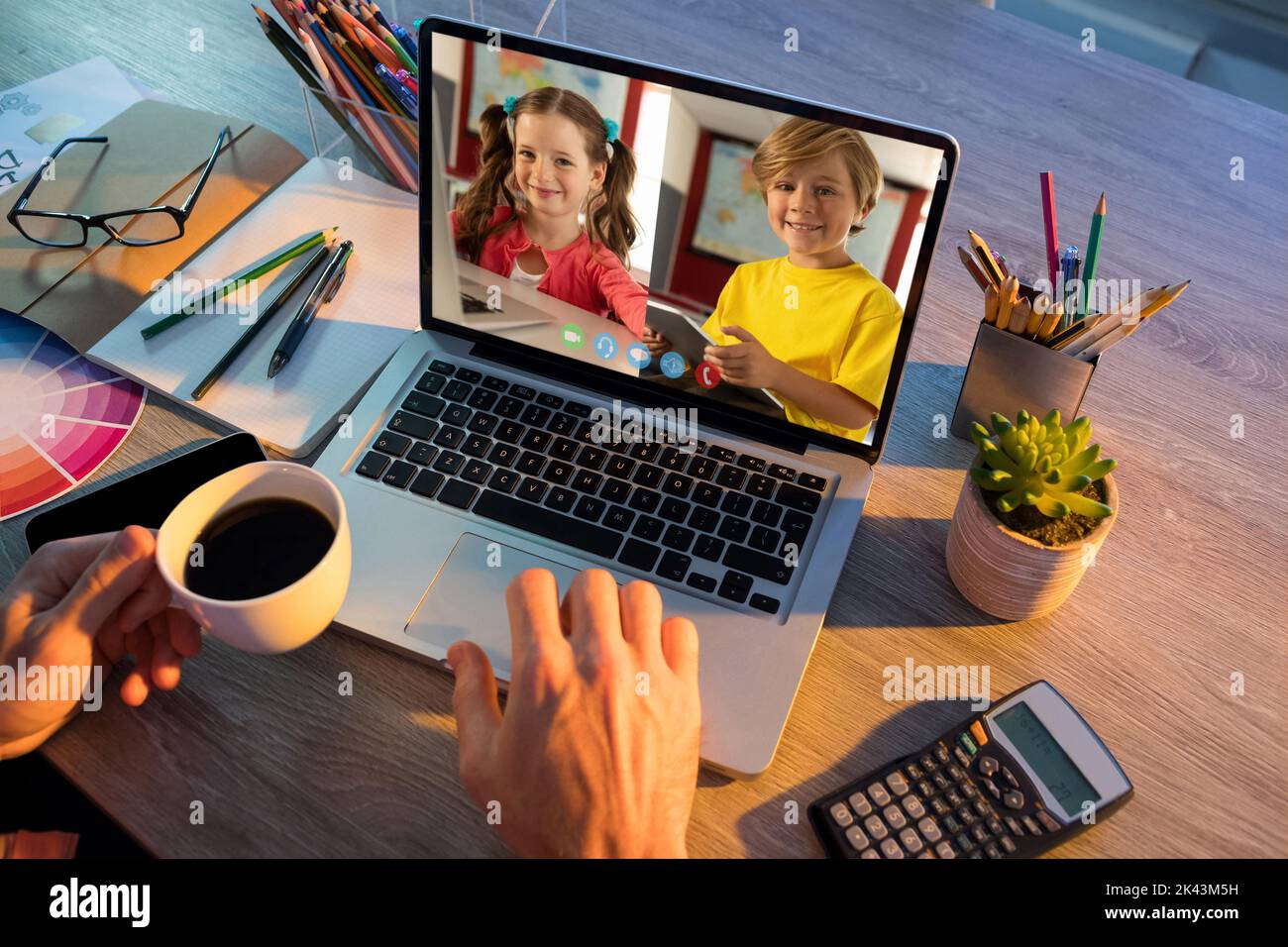 Female teacher having a video conference with male and female student ...