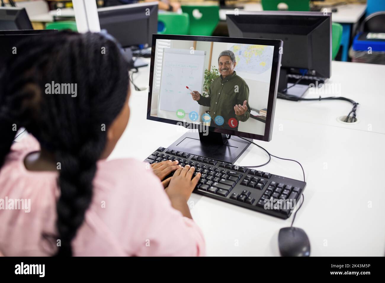 Female student having a video call with male teacher on computer at ...