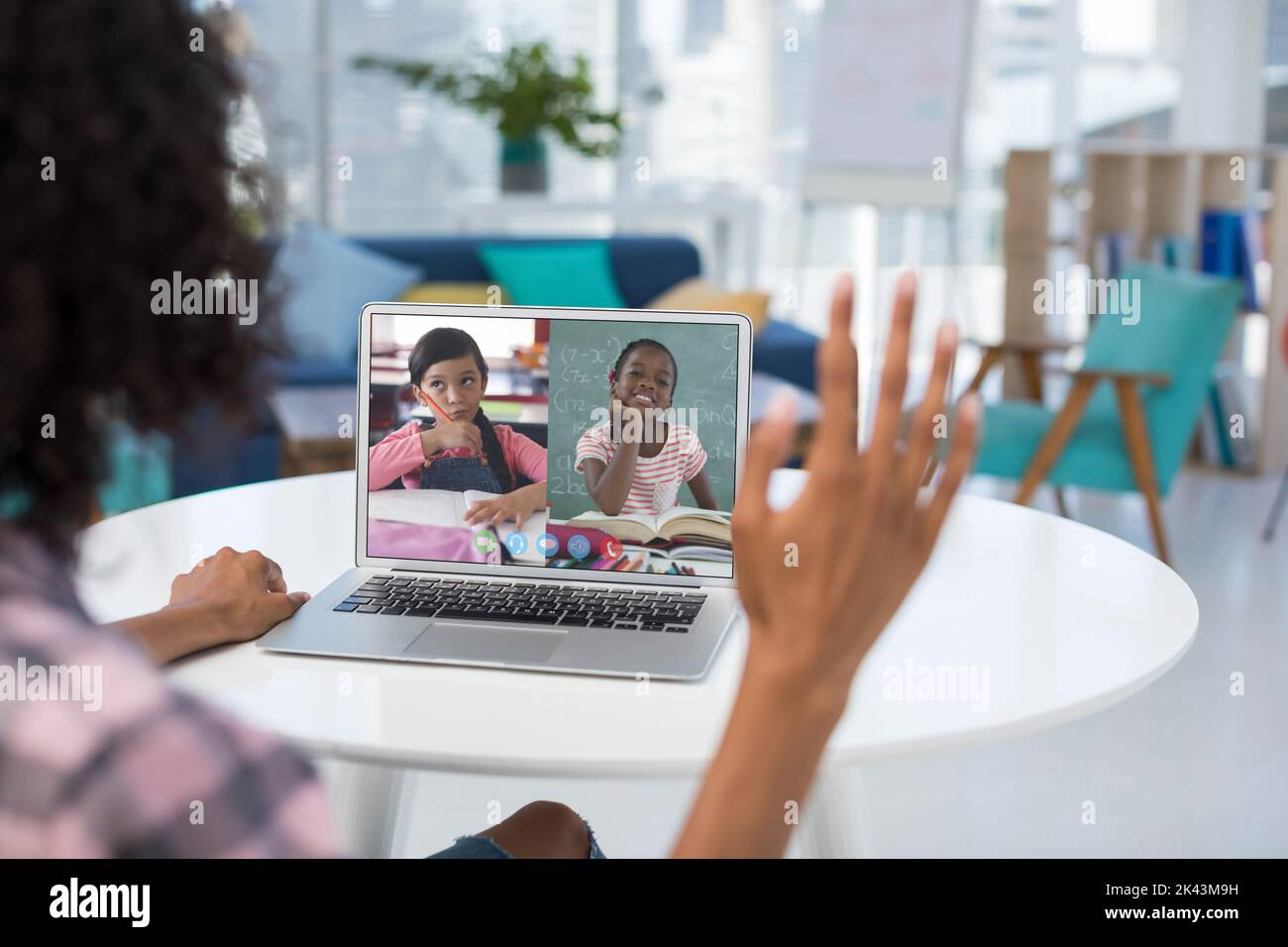 Female teacher having a video conference with two female students on ...