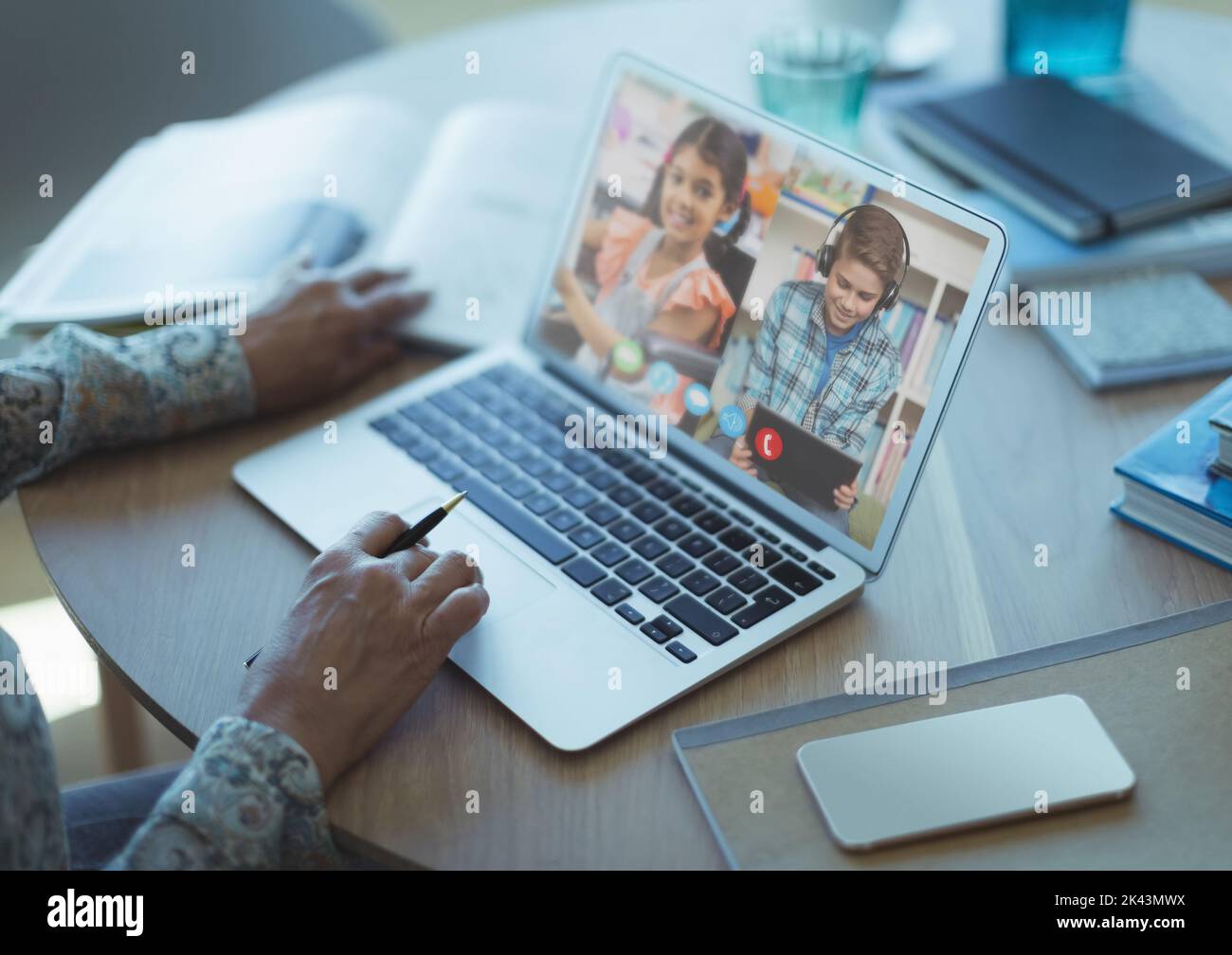 Mid section of female teacher having a video conference with male and ...
