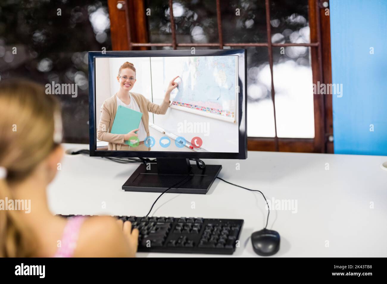 Female student having a video call with female teacher on computer at ...