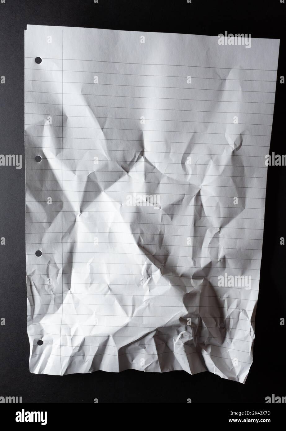 Hole punched sheet of lined white notebook paper, scrunched at bottom