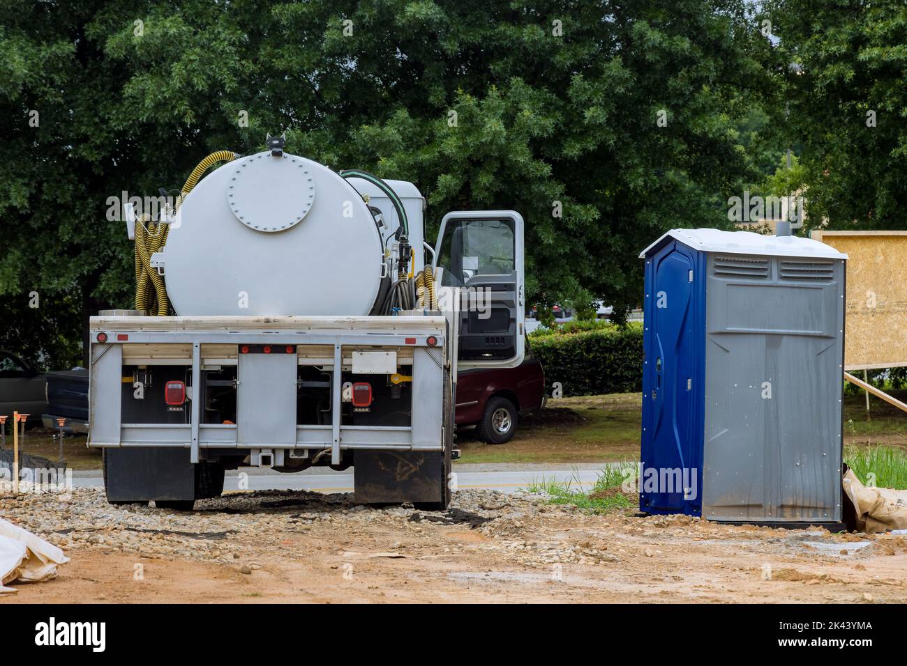 Cleaning portable restrooms with the help of a septic truck Stock Photo