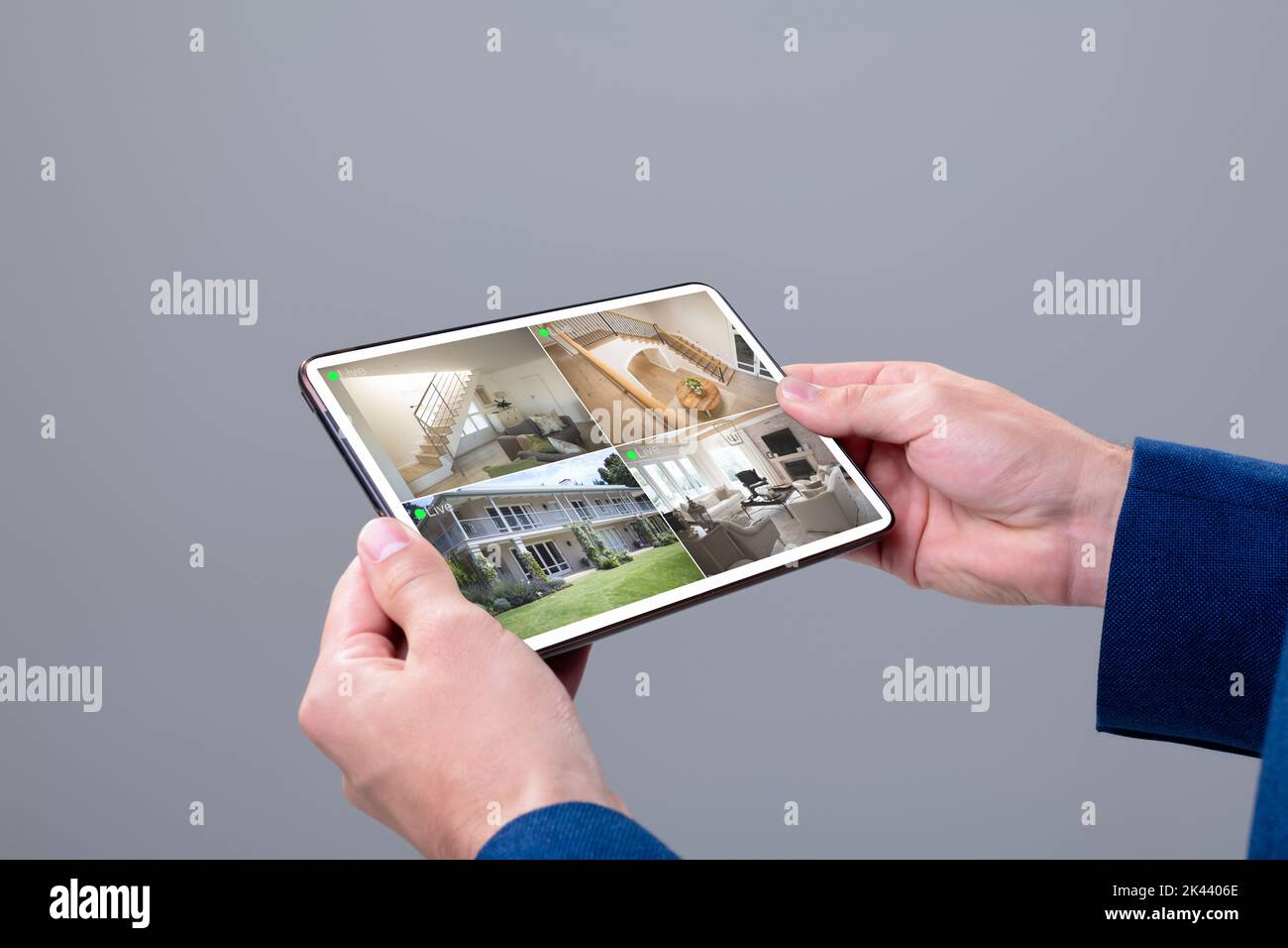 Hands of caucasian man holding tablet with view from security cameras ...
