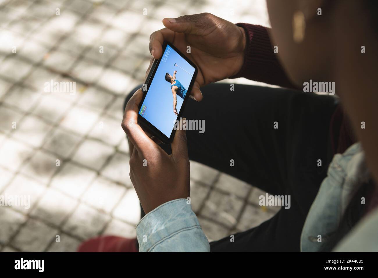 African american man in park watching male athlete throwing discus on
