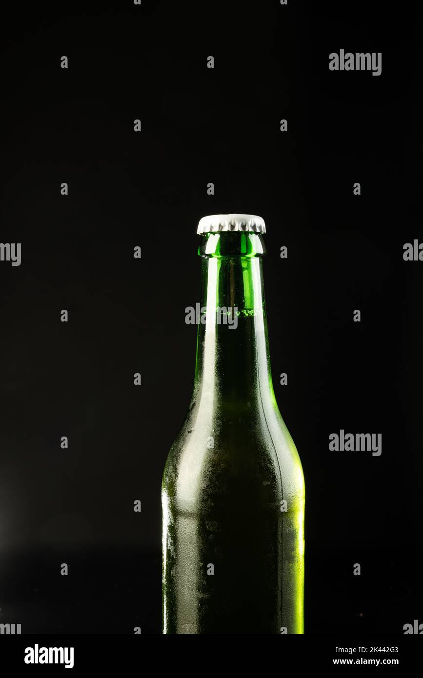 Image of green glass beer bottle with white crown cap, with copy space
