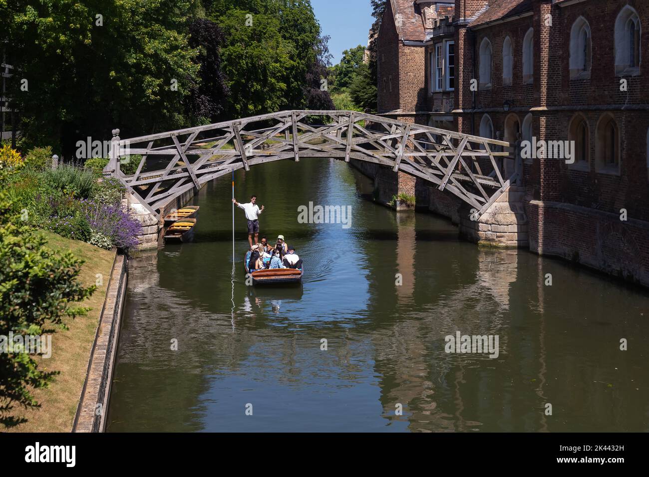 People relax on a punt tour on the River Cam, passing through the mathematical bridge which runs through the heart of Cambridge, UK.22.06.22. Stock Photo