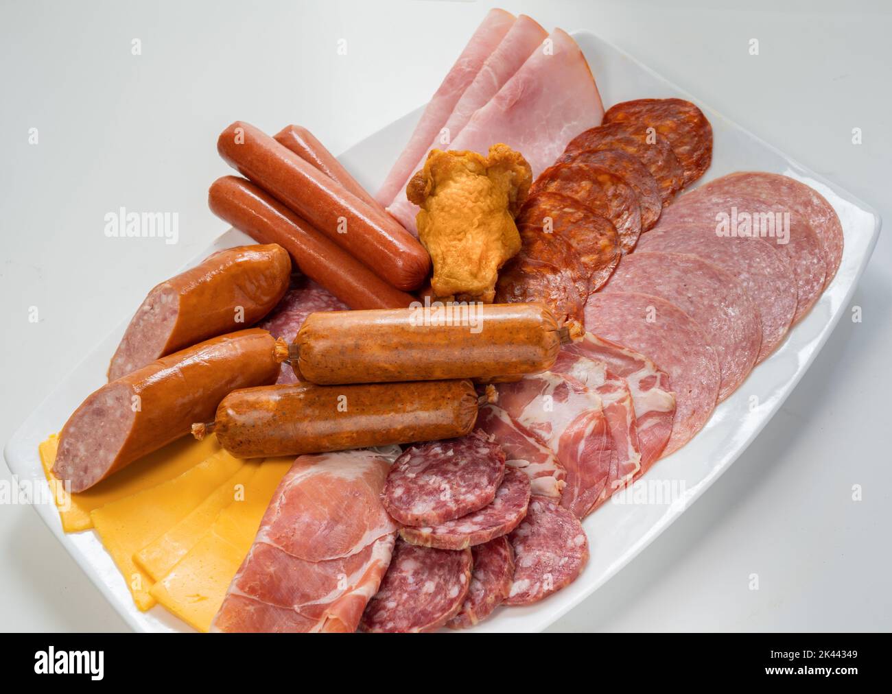 Plate filled with unhealthy processed meats and cheese Stock Photo