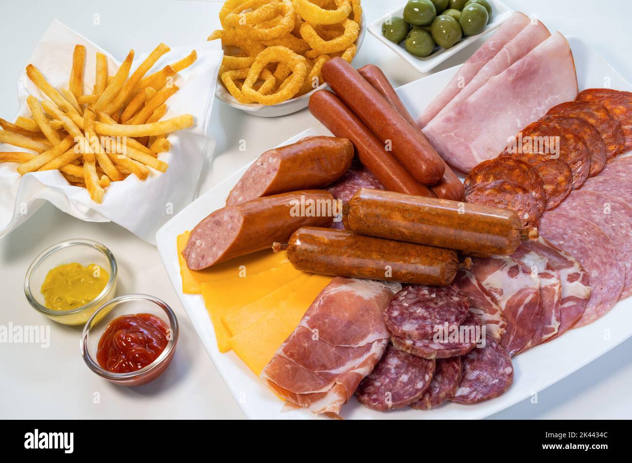 Assorted unhealthy processed and fried foods on table Stock Photo